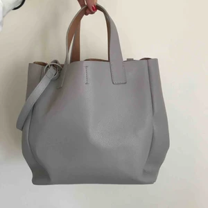 Väska - Söt handväska från zara i gråbeige färg. Roséguld färgad inuti. Bra skick. Kommer med en tillhörande typ av plånbok i roséguld som går att ta bort. Det längre väskbandet går också att ta bort. Köpare står för frakt