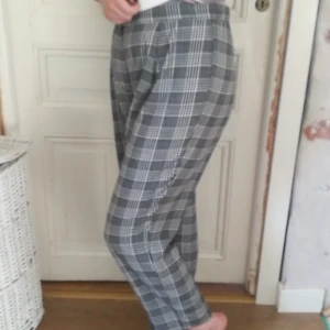 Rutiga högmidjade kostymbyxor - Kostymmodell, lite tunnare material och rutigt mönster. Material: 100% polyester