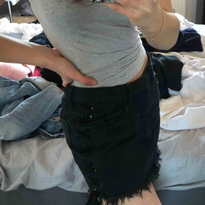  - Jeanskjol från junkyard med snörning på sidorna, den är kortare framtill och längre där bak. Säljer den pga att den är för stor på mig som vanligtvis bär S. Använd ngn gång<33