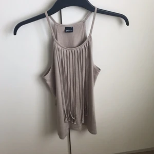 - En snygg topp från Ginatricot i storlek XS (som även passar S). Den är i mockaimitation och har fransar hängandes från kragen.