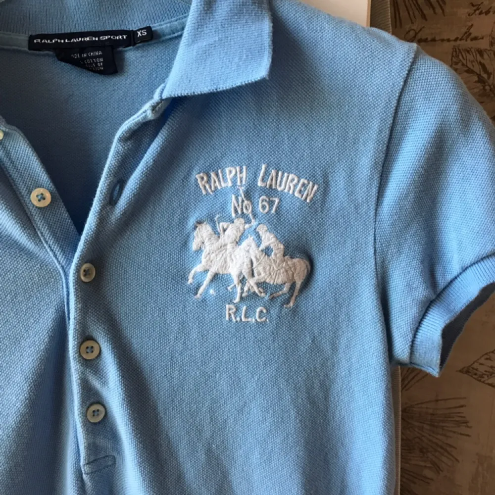 Ralph Lauren sport piké. Aldrig använd förutom på bilden. Ljusblå med vitt märke. . T-shirts.