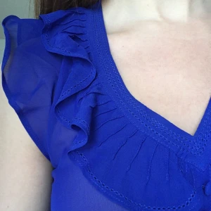  - Skir indigofärgad blus med volanger och band på baksidan. 