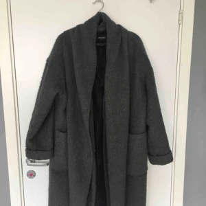  - Grå kappa som går ner till knäna. Vindtätt och varmt material som funkar för både höst och vinter! Det är en halsduk insydd som ger ett mysigt resultat. Finns knappar under. Köpt på Monki. 300 kr. Inga fläckar. Skickas för 50 kr extra🌸🌸