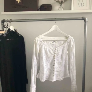  - Figursydd broderie anglaise blus från spira/fira med dekorativa knappar fram och vid ärmslutet. Passar storlek XS-S. Köparen står för frakten.