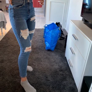 Slitna jeans från Topshop - Sköna stretchiga jeans från Topshop i modellen JAMIE i storlek W28 L30, lite av slitningarna har försvunnit på knät som ni ser på bilden. Passar perfekt på mig som brukar ha S & är 165cm, möter upp i Umeå annars står köparen för frakten:)