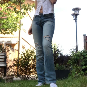 Slitna jeans - Sjukt snygga jeans i low waist modell med slitningar på benet och lite utsvängda ben! Modellen är 175cm vilket gör att Jeansen passar till olika längder! Midjan är 25 men Passar Modellen som är mellan 26/27 , köparen står för frakt!🥰