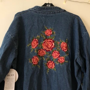 Kimono jeansjacka - Superfin kimonoaktig jeansjacka med skärp & fint rosentryck. Aldrig använd! Lappen kvar! Frakt tillkommer & betalas av köparen. 