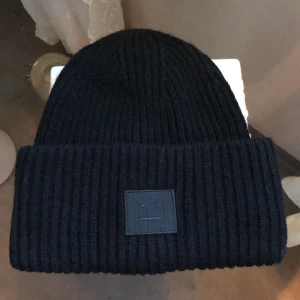 Svart Acne mössa  - Jag säljer min fina acne mössa pågrund av att jag inte använder den längre. Köpt förra säsongen 🌾 Använd fåtal gånger och är i väldigt bra skick 💛