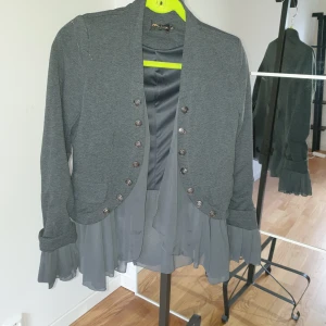 Jacka/kofta - Grå jacka/kofta/kavaj med tyllinslag knappar på båda sidor 