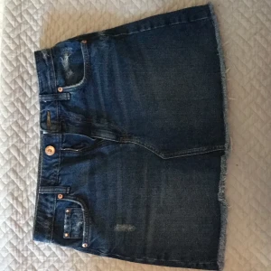 Jeanskjol från River Island storlek UK 8 - Snygg jeanskjol i mörkare färg från River Island. Helt oanvänd och i super skick. Storleken är UK 8 vilket motsvarar EU 36. 