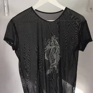  - Genomskinlig svart T-shirt ifrån Humana, köparen står för frakt