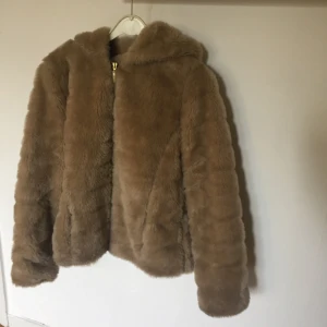  - Beige/brun (fejk) pälsjacka med dragkedja och luva! Varm och gosig perfekt till hösten och vintern