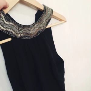  - Helt oanvänd topp från Vero Moda. Hög hals med knytning på ryggen. 