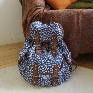  - Säljer min söta småblommiga ryggsäck jag köpte i London för några år sedan. Yttertyg i bomull, läderimitation på detaljerna och innertyg i polyester. 