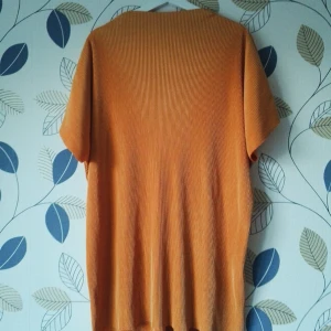  - Tröja från Weekday i annorlunda material. Kan användas som kort klänning eller tunika pga lite längre. Aningen längre baktill. Ribbad med högre krage fram och bak. I världens finaste orangea färg som passar perfekt till både höst och vår! strl S men passar XS-L beroende på hur man vill att den ska sitta. 