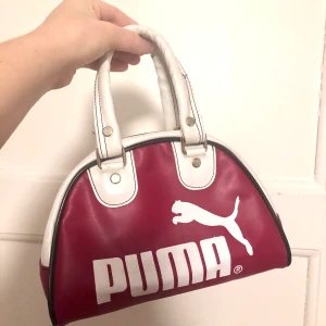 Vintage Puma handväska mini 90-tal 00-tal  - Säljer denna coola lilla handväska från Puma! I gott begagnat skick. Vinröd och vit. OBS: pris sänkt till 100 då en söm gått upp- se bild 2.