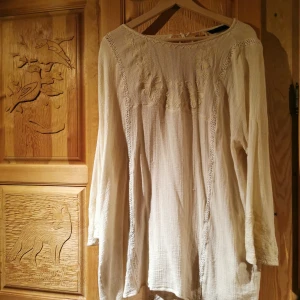 Kortare klänning/strandklänning - Tunn superskön kortklänning/strandklänning som är fantastisk i oversize, känsla 70 tal. Vackra broderier pryder både fram och bak samt snörningen baktill. Armarna något utsvängda. Bilderna är ej bra tagna men vill bara få ut mina plagg, om du köper plagget tvättar jag det självklart innan! 