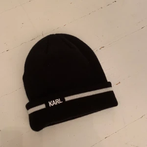 Karl Lagerfeld mössa  - Säljer denna helt oanvända svarta mössan ifrån Karl Lagerfeld! Köpte den för ett par år sedan men bara aldrig använt den så den ser precis ut som ny! 