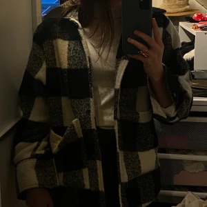 Rutig Jacka - Svart, vit, rutig jacka inköpt från by Anastasia. Sparsamt använd. Köpare står för eventuell frakt