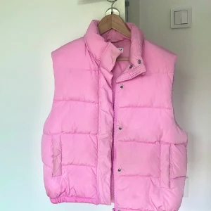 Rosa puff-väst - Nyskick, använd endast fåtal gånger. Storlek S och har fin passform. Älskar den puffiga strukturen och färgen är PERFEKT! Köpte den för 499kr på Carlings men säljs för 250kr. Buda i kommentarerna: högsta bud just nu 400kr🤠