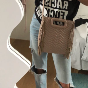 Maje väska - Jag säljer nu min väldigt fina väska från Maje då den inte kommer till användning. Inga slitningar varken fram eller bak på väskan. Dustbag finns. Ett band som det går att justera längden på. Färgen är lite mer beige och mindre rosa i verkligheten. 