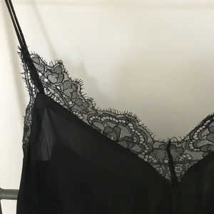 Festlig topp med spets - Svart linne med spetskant, från H&M. Fint skick! 