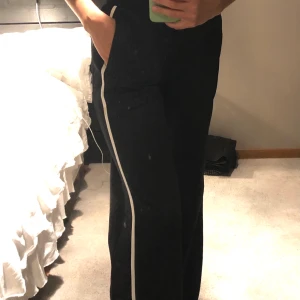 mjukisbyxor  - Byxor med vit linje längst med benet och knappar vid vaderna 🤎 storlek S, säljer för 70 och frakten ligger på 44kr 🤍