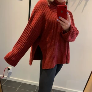 Röd stickad tröja- weekday - Mysig röd hösttröja från Weekday. Höghalsad och med slits på sidorna vid midjan. Storleken är S men fungerar minst lika bra till M. 