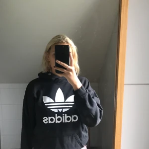 Svart adidashoodie - Säljer min adidashoddie, används inte och är i ett bra skick, knappt använd, saknas snöre men själv tycker jag att det är snyggare utan. Pris kan diskuteras!