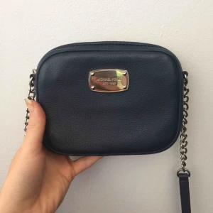  - Säljer en jättefin MichaelKors väska i marinblått kalv-läder. Silvriga detaljer och beige innertyg. Är i jättebra skick, givetvis äkta. Kan mötas upp i Kungsbacka, Göteborg eller Borås efter överenskommelse. Annars tillkommer 32kr frakt 