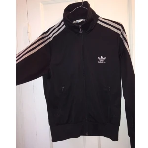  - Klassisk Adidasjacka med tryck på ryggen. Bra skick!   Storleken är 42 men den är liten, närmare en 38!