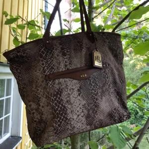  - Helt ny Ralph Lauren väska med detaljer i guld.Äkta, men har tyvärr inte kvitto då jag fick den i present. Säljer den nu, använd endast en gång, för att den inte kommit till användning. Snygg, rymlig och lätt att matcha.