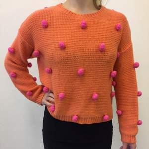 Orange Stickad tröja med rosa stickade bollar. 