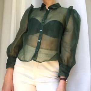 Blus i organza - Mörkgrön blus i organza med fin puffärm! Från Monki. Säljes pga kommer ej till användning🦚