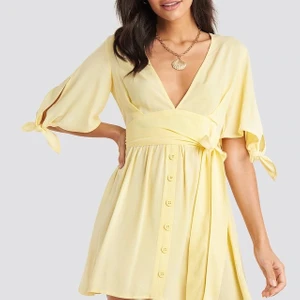 Gul klänning med fina detaljer  - Klänning från nakd, fina detaljer och luftigt material. Använd 1 gång så är i nyskick. Köpt för 400kr. Frakten är inkluderad 