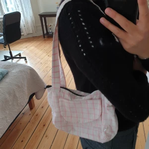 Vitrosa baguettväska - Säljer min egensydda baguett väska som är vitrutig😊den är väldigt rymlig och skön att ha över axeln, fina färger nu till sommaren💗🌞den har ett litet och ett stort fack innuti samt två på utsidan! 