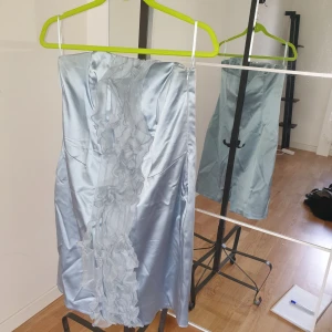 Ljusblå ärmlös festklänning  - Fest klänning med tyllkrås framtill utan ärm 