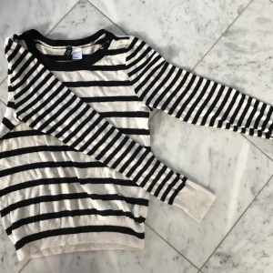 Randig tröja - Randig tröja i Lite tjockare material. Second hand, så inte i nytt skick. Säkerhets nål vid kragen. Lite nopprig. 