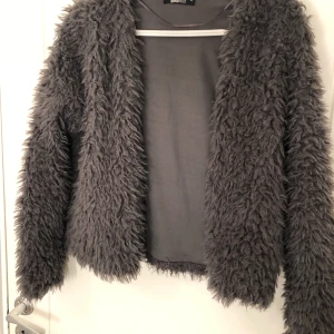 Grå kofta Gina tricot - En grå lurvig kofta från Gina tricot i stl M, använd ett antal ggr, inga märken eller revor på plagget 