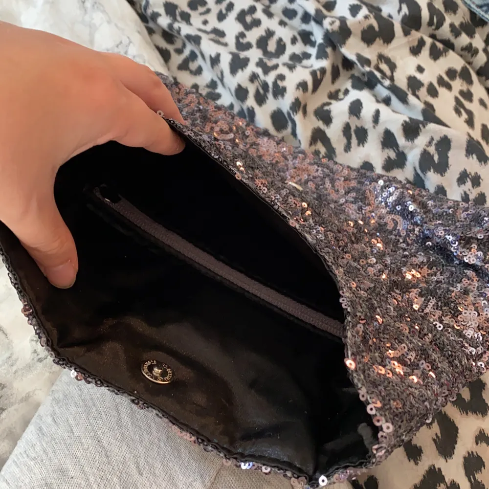 En clutch från victorias secret, full med paljetter. Kan användas både som clutch men också som neccesär. Kan öppnas 2 på sätt, båda sätten leder till samma fack, dvs det finns bara ett fack. . Väskor.