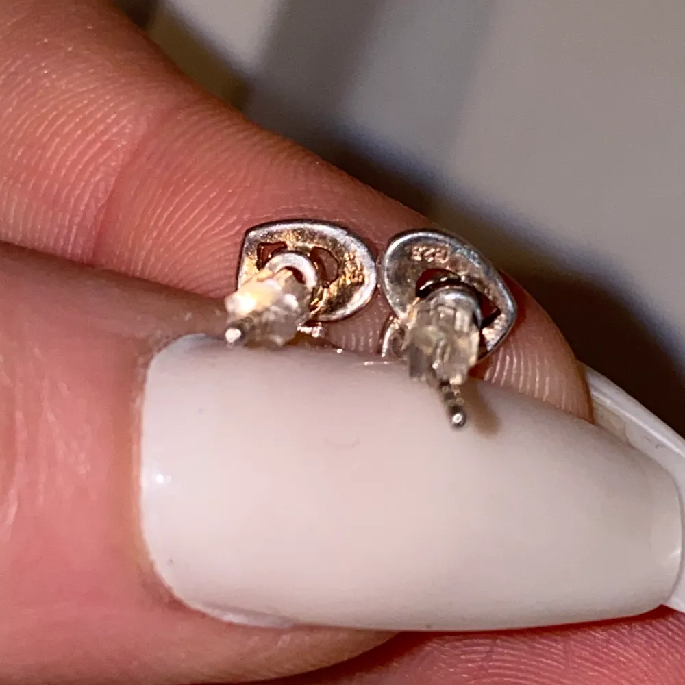 Små hjärtformade äkta silver örhängen med små kristaller i mitten. Nästa bild ser man stämpeln att det är äkta . Accessoarer.