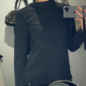 Svart polotröja  - Svart polotröja. Stor storlek men passar på alla beroende på hur man vill att den ska sitta