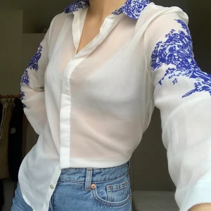 Skjorta med mönster - Säljer min fina vita skjorta med blåa detaljer. Dock är materialet inte det ”normala” skjortmaterialet utan en tunnare och mer luftig variant. 💞 köparen står för frakten men jag möter även upp i Lund💞 