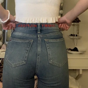 Hilfiger Jeans - Mid-rise jeans från Hilfiger med text broderad på baksida. Är osäker på storleken men är ca 30 i benen och passar ca 24-26 i midjan. Jag är en Xs och 34 i byxor.