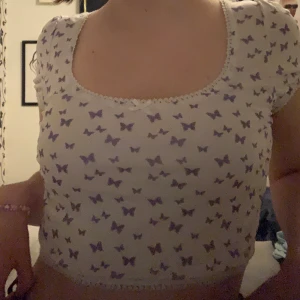 Butterfly t-shirt - Croppad tröja med lila fjärilar. Aldrig använt. Storlek S/M. Frakt tillkommer (22kr)