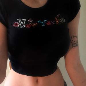 Jätte fin crop top med New York och lite blommor skrivet på med glitter stenar💕 Storlek S men tror att den potentiellt kan passa M också :) buda!<3