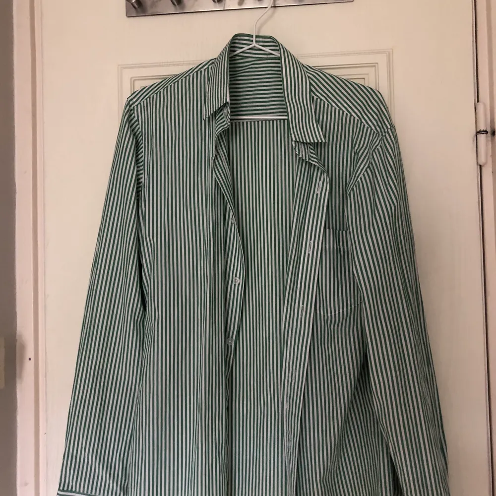 En super snygg oversize grön och vit randig skjorta. Köpt secondhand har själv bara använt den ett fåtal gånget. Skjortan är i bra skick . Skjortor.