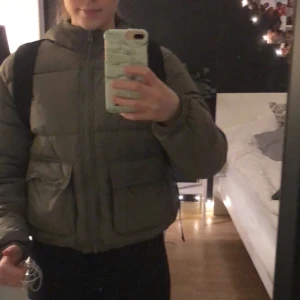 dunjacka från hm - En vinter/höst jacka från hm som är mörkgrön. köptes för ungefär 10 månader sen och använts under hela vintern, inga konstigheter, inga sminkfläckar och inga skador på jackan. Jag tänker sälja jackan för 200kr INKL frakt