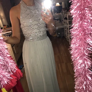 Grå balkänning  - Grå balklänning i storlek 34. Uppsydd i fållen. Använd en gång. Ny pris 1699 säljes för 400. Köparen står för eventuella fraktkostnader. 