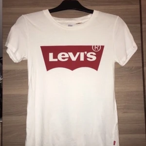 Vit Levis t-shirt  - Oanvänd vit Levis t-shirt i rött tryck. Priset kan diskuteras! 